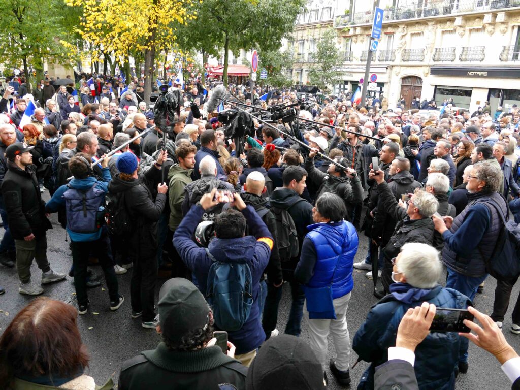 Salvador Allende Square, Paris (7th Arrondissement), November 12, 2023, March against anti-Semitism. National Rally elected officials, Marine Le Pen and Jordan Bardella surrounded by journalists. Siren-Com, CC BY 4.0, via Wikimedia Commons